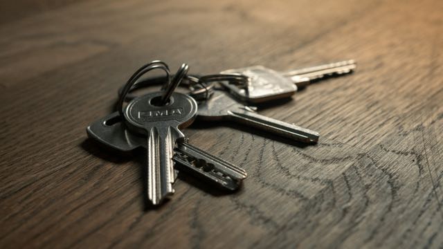 A ring of house keys on a wooden table
